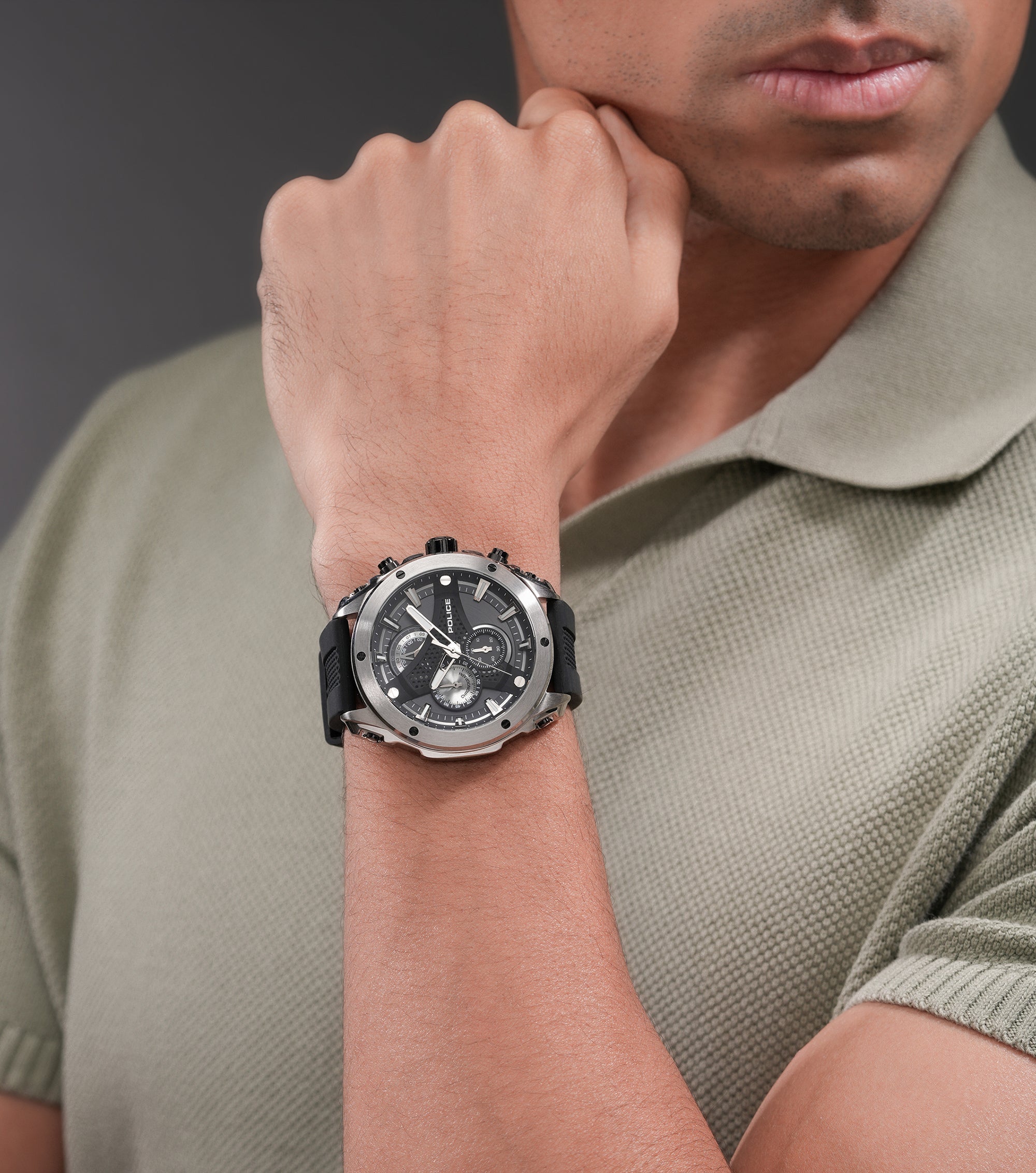 Silver-toned stainless steel watch with a black chronograph dial, silver-toned hour markers, and a black silicon strap.