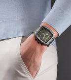 Gunmetal-toned rectangular watch with a green geometric dial, three subdials, black silicon pushers, and a green nylon strap.