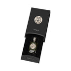 Dark green perfume bottle with gold-toned cap and ornate "M" emblem, inside a black box with matching emblem and "Gamayun" te