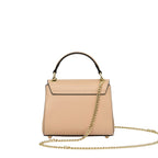 Nude structured leather top-handle bag with a black handle, gold-toned hardware, a long gold-toned chain strap, and four feet