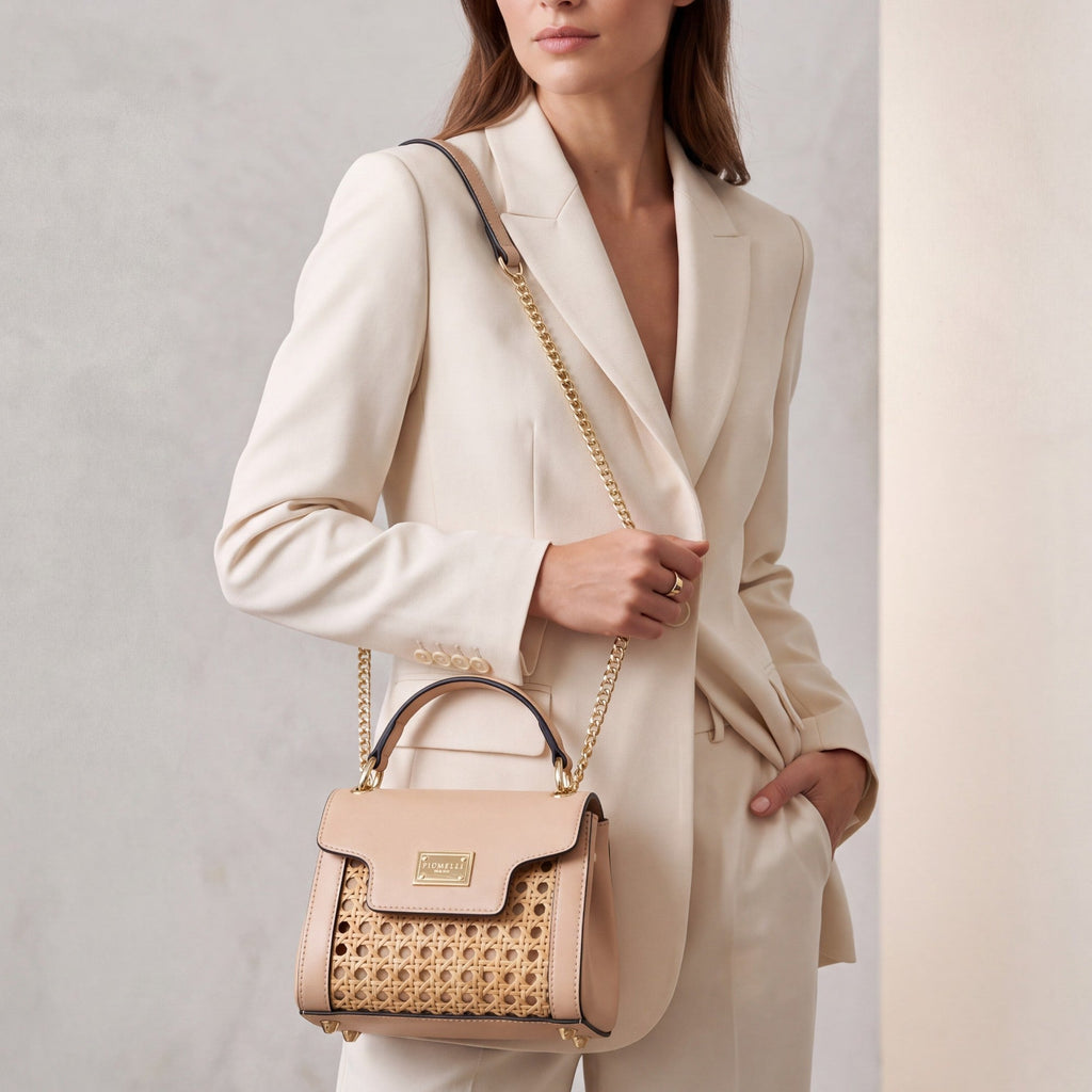 Nude leather and woven cane structured bag with a top handle, front flap, gold-toned hardware, and a chain shoulder strap.