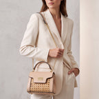 Nude leather and woven cane structured bag with a top handle, front flap, gold-toned hardware, and a chain shoulder strap.