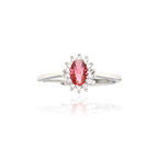 Silver-toned ring featuring an oval-cut ruby-red central stone surrounded by a cluster of small clear stones.