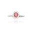 Silver-toned ring featuring an oval-cut ruby-red central stone surrounded by a cluster of small clear stones.
