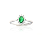 Silver-toned adjustable ring with an oval green stone surrounded by a halo of small clear stones.