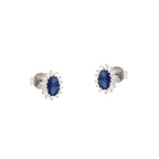 Pair of silver-toned stud earrings, each with an oval dark blue stone surrounded by a halo of small clear stones.