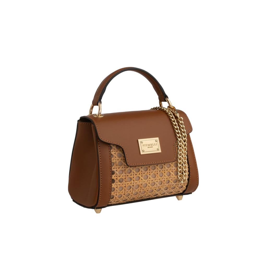 Structured brown leather top handle bag with a cane woven front panel, gold-toned hardware, flap closure, and side chain.