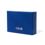 A closed rectangular OJAR presentation box made of premium blue textured leather with the brand name "OJAR" embossed in gold on the front, set against a white background.
