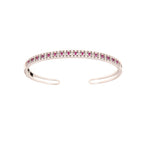 Silver-toned open cuff bangle with a top row of rectangular ruby-colored stones flanked by clear round stones.