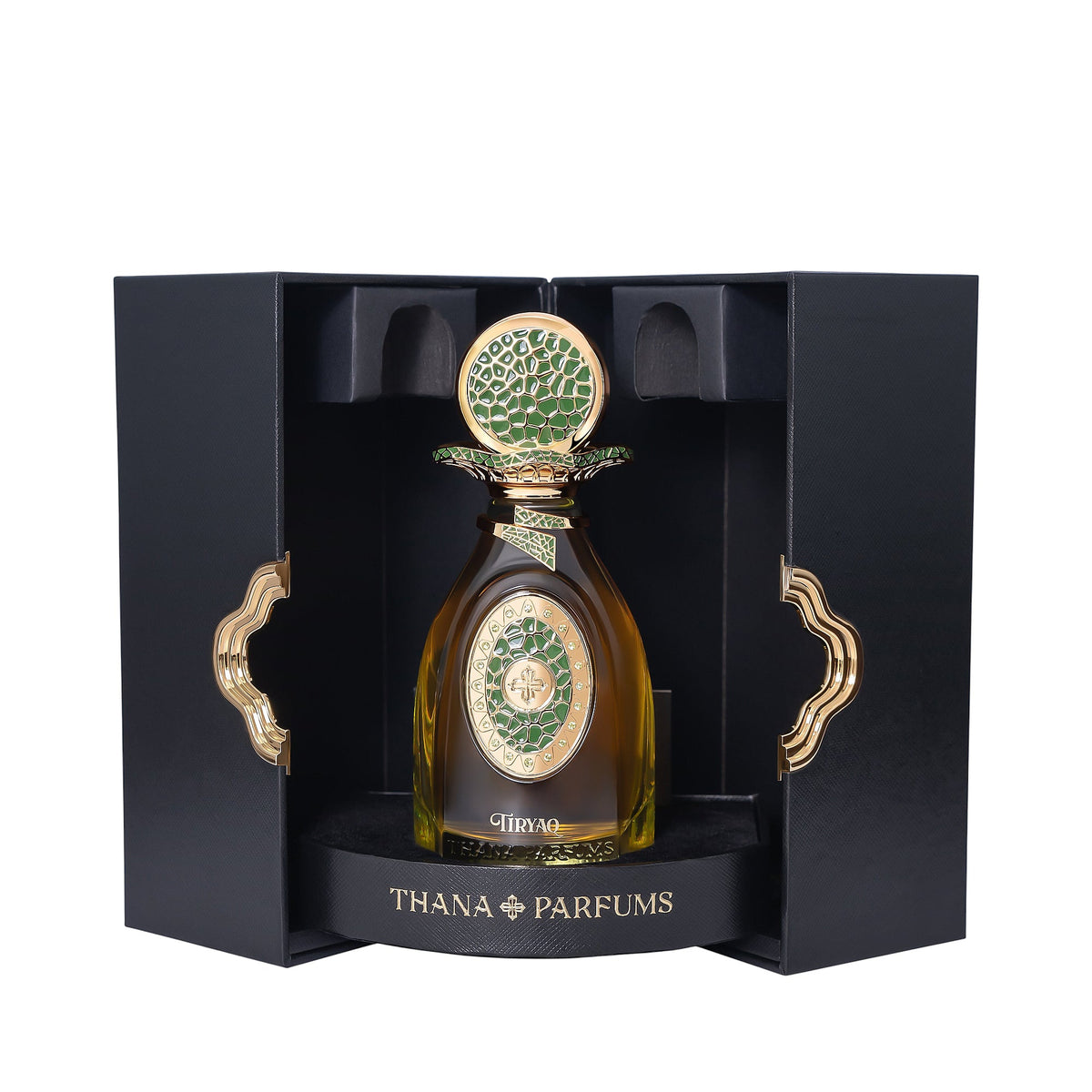 Amber perfume bottle with gold-toned cap and green mosaic details. In open black box with gold-toned wavy handles.