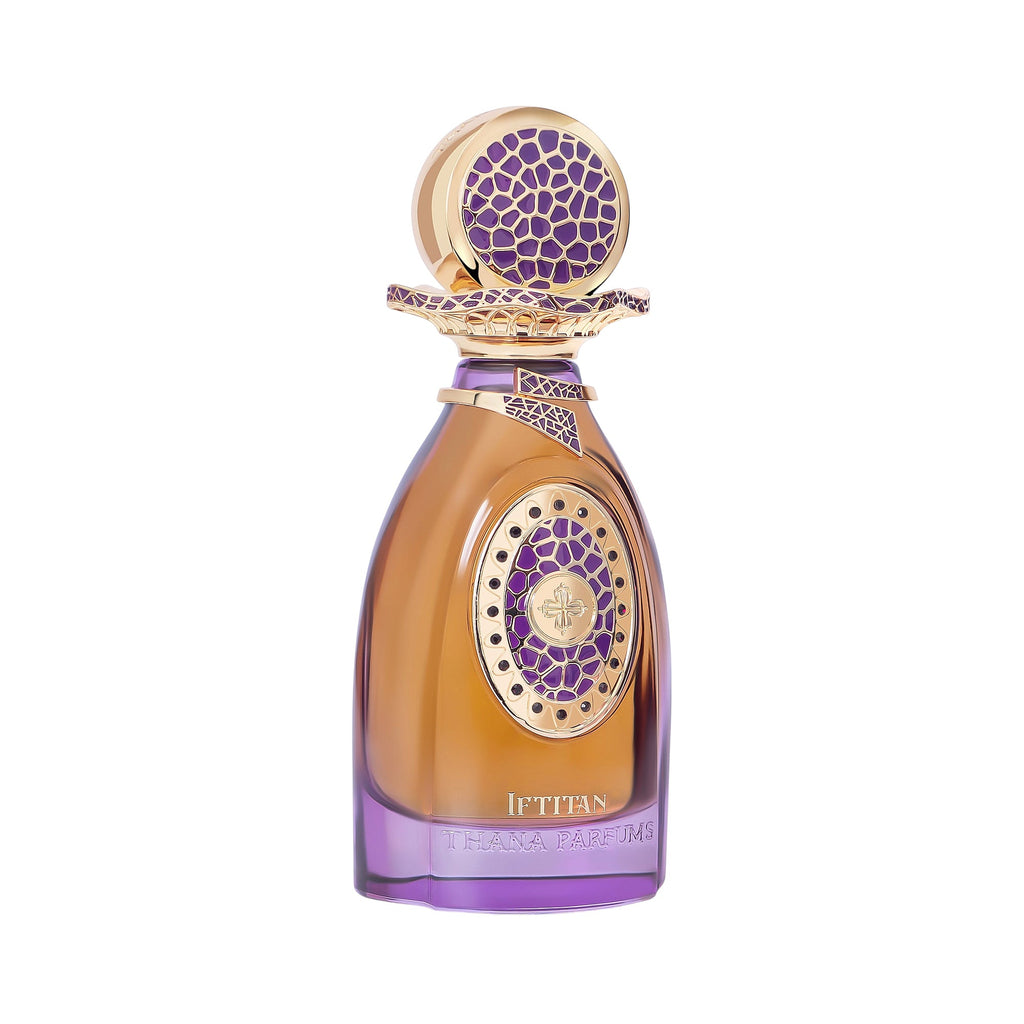Amber perfume bottle with purple base. Gold-toned cap, collar, and front oval frame have purple patterns, with a cross emblem