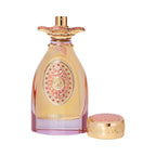 Gold-toned, curved glass perfume bottle with a pink-purple base, an oval coral-pink emblem with gems, and a matching ornate c