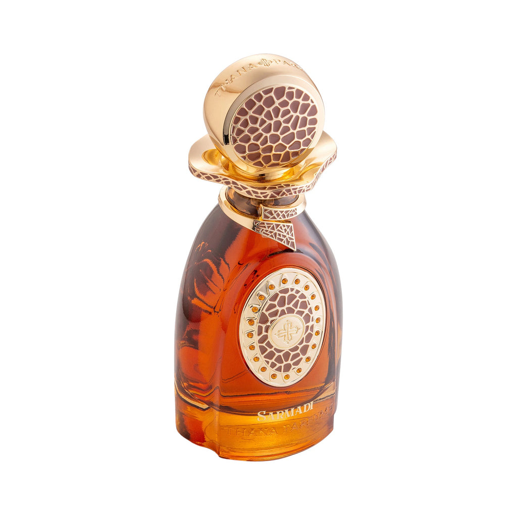 Amber glass perfume bottle with a gold-toned spherical cap and ornate collar, both featuring textured brown patterns. Gold-to