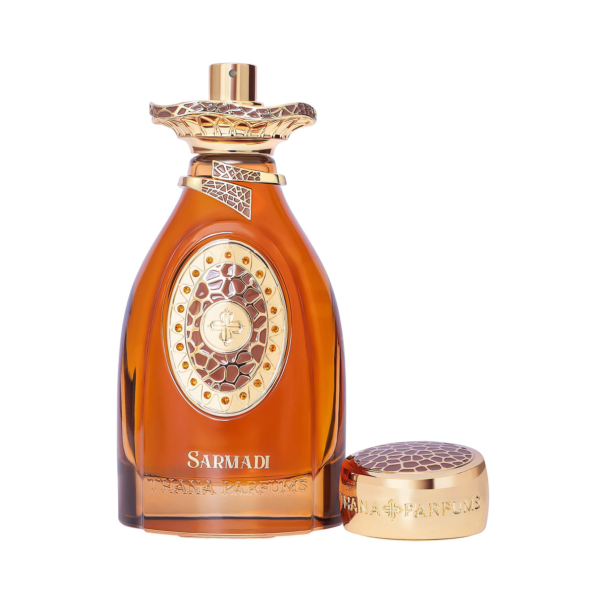 Amber glass bottle with gold-toned trim and cap. Front emblem has a cross, brown texture, and small gems.
