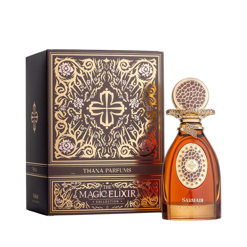 Dark brown box with gold-toned ornate patterns. Amber glass perfume bottle with a gold-toned ornate cap and central design.
