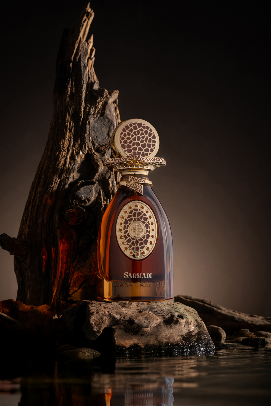 Dark amber perfume bottle with gold-toned ornate collar, round cap with brown giraffe-like pattern, and gold-toned oval label
