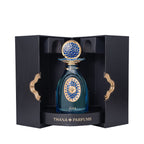 Teal glass perfume bottle with gold-toned and blue mosaic patterns, topped with a matching cap, presented in an open black bo