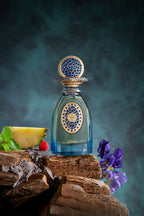 Blue-tinted glass perfume bottle with light blue liquid. Features a gold-toned cap and label, both with intricate blue mosaic