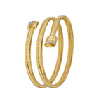 A three-quarter vertical display of the gold coiled Tubogas bangle, showing the smooth spiral layers and the side-aligned crystal detailing on the rounded end caps.