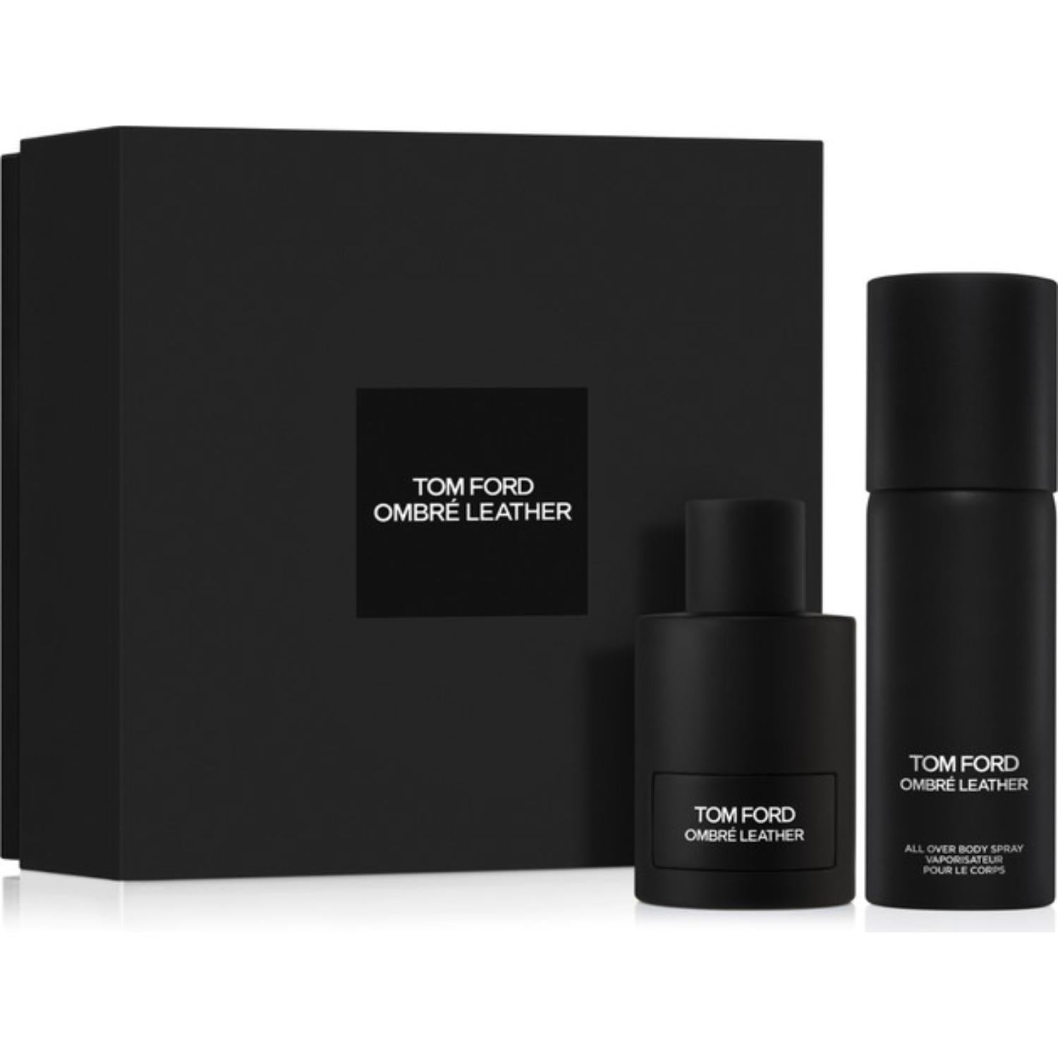 Tom Ford Noir Extreme gift set showcasing a large ribbed gold presentation box with a centered black logo square, a sleek rectangular translucent black perfume bottle with a gold cap, and a matching black cylindrical travel atomizer.