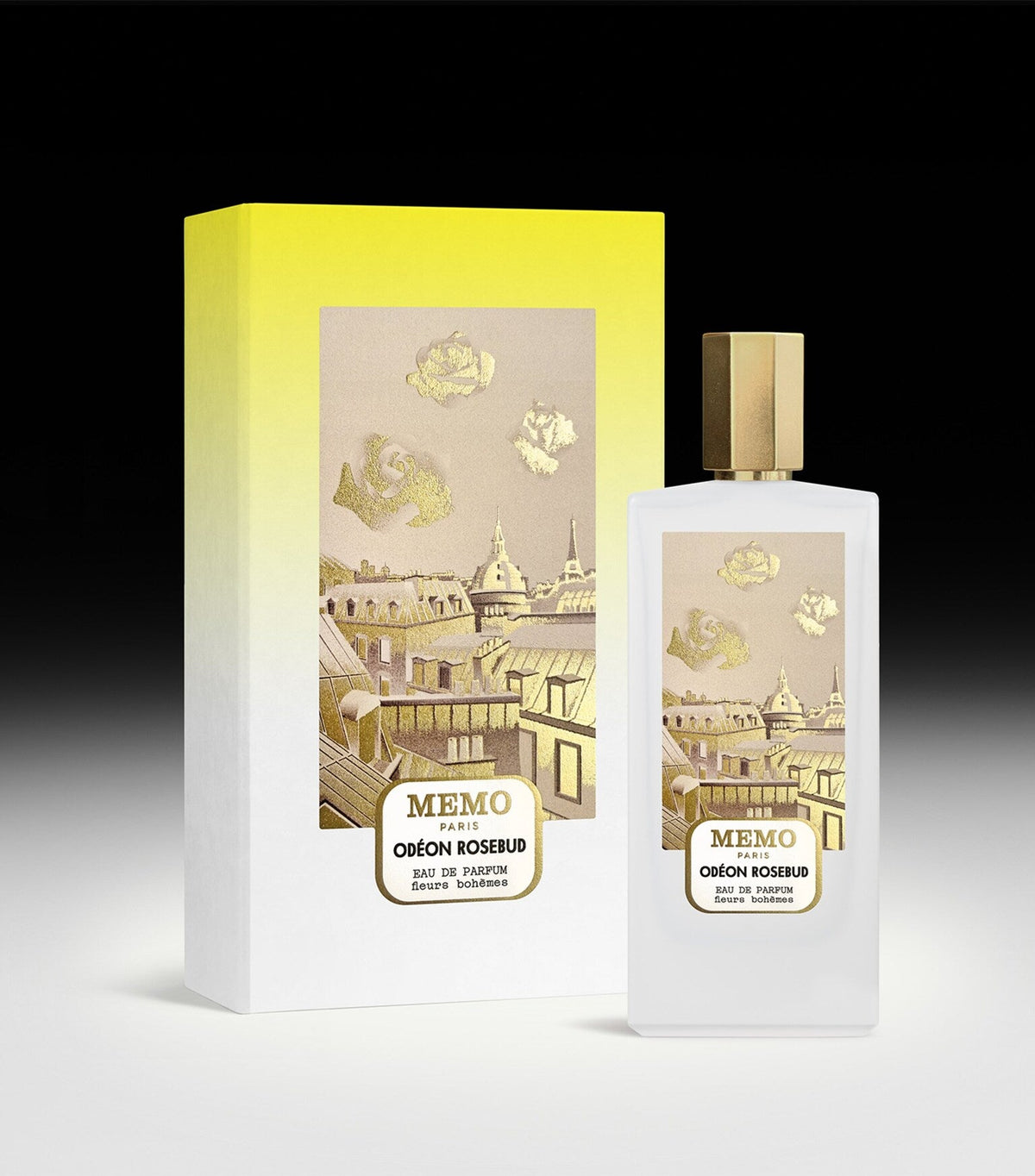 Frosted glass perfume bottle with a gold-toned faceted cap and a label showing a Parisian cityscape with gold-toned rosebuds.