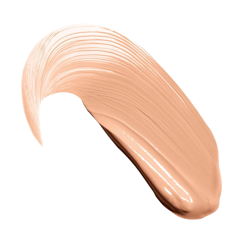 A curved swatch of light peach-toned liquid concealer with visible brush strokes and a glossy finish.