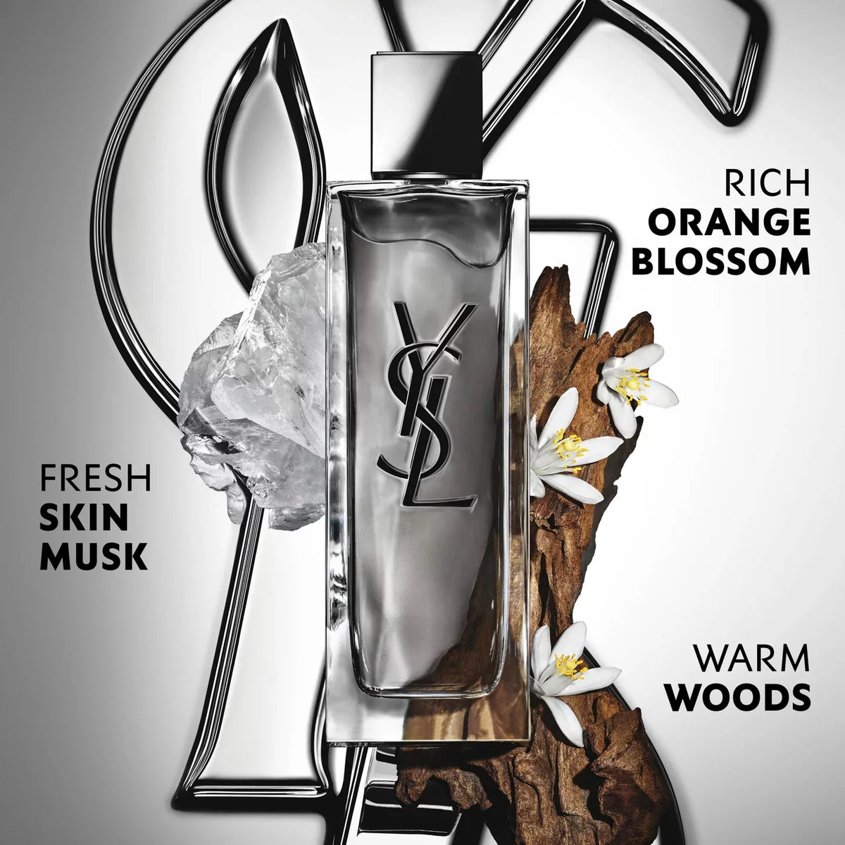 Rectangular glass perfume bottle with clear liquid, a black YSL logo, and a silver-toned metallic cap and base.