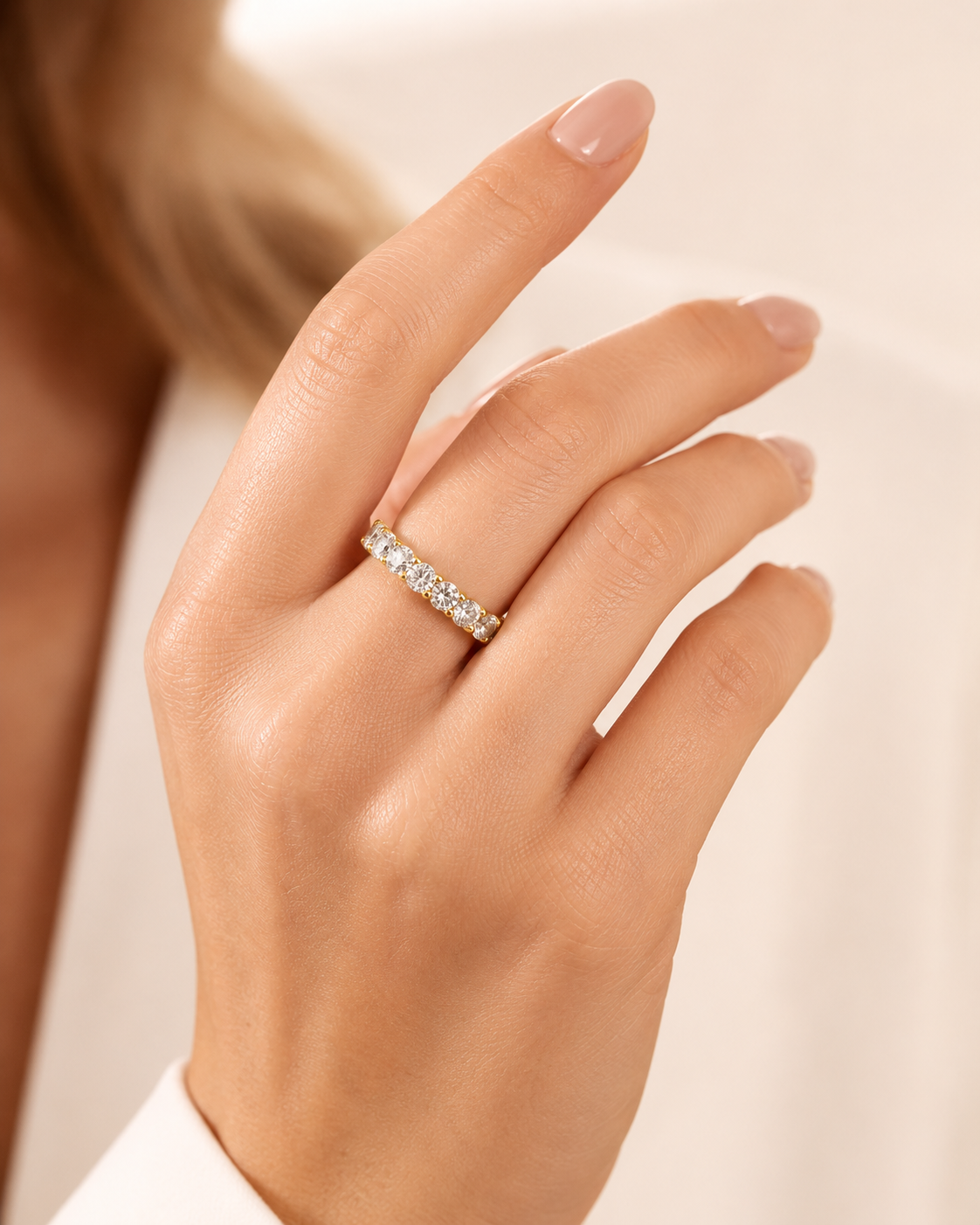 Gold-toned eternity ring with a continuous line of round, clear stones set closely together.