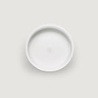 Top view of a white, circular candle with a smooth surface and a slight central indentation.