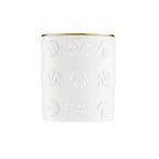White cylindrical candle with a gold-toned rim and embossed patterns of horse heads, crests, and "CREED" text.