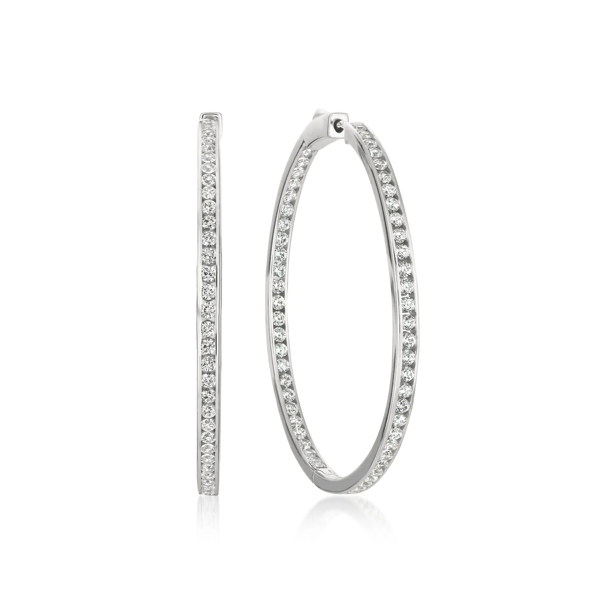 Pair of silver-toned inside-out hoop earrings with clear sparkling stones set along both inner and outer surfaces.
