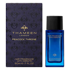 Thameen Peacock Throne Hair Fragrance 50ml in a blue glass bottle with a black ribbed cap, next to its dark blue patterned bo