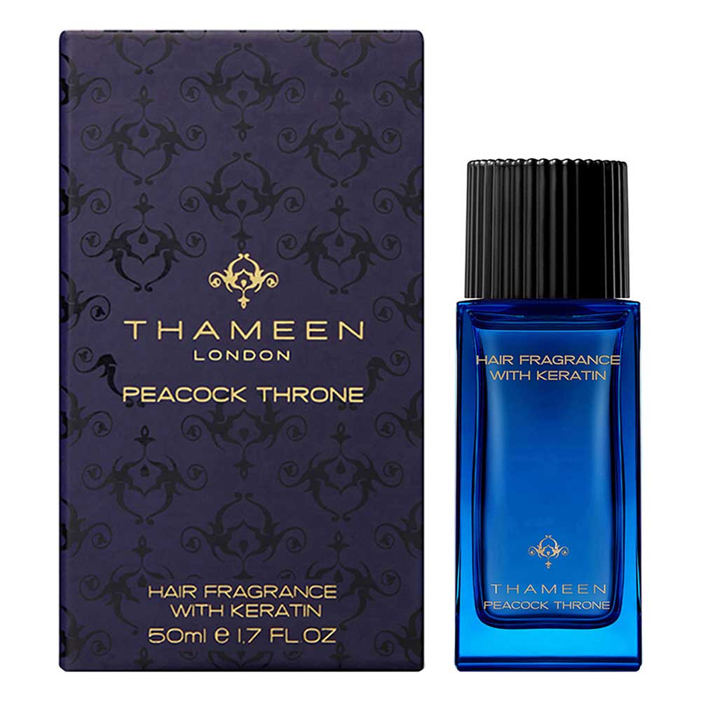 Thameen Peacock Throne Hair Fragrance 50ml in a blue glass bottle with a black ribbed cap, next to its dark blue patterned bo
