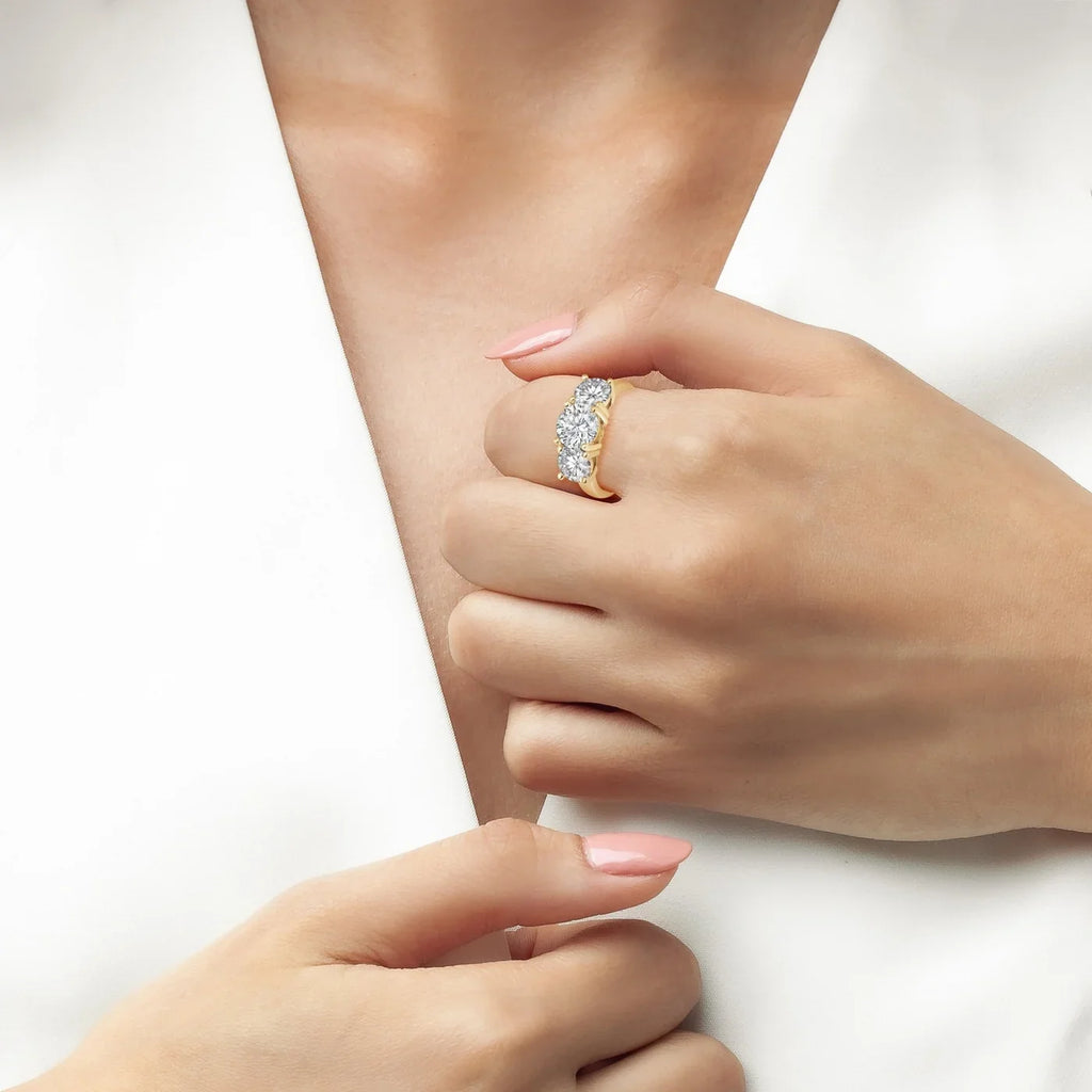 Gold-toned ring with three large, round, clear stones set across the top.