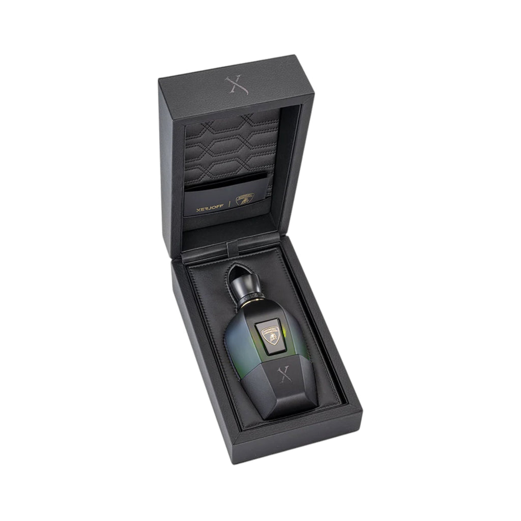 Faceted perfume bottle, dark green-to-black gradient, gold-toned cap, bull logo, silver 'X', in open black box with quilted l