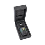 Faceted perfume bottle, dark green-to-black gradient, gold-toned cap, bull logo, silver 'X', in open black box with quilted l