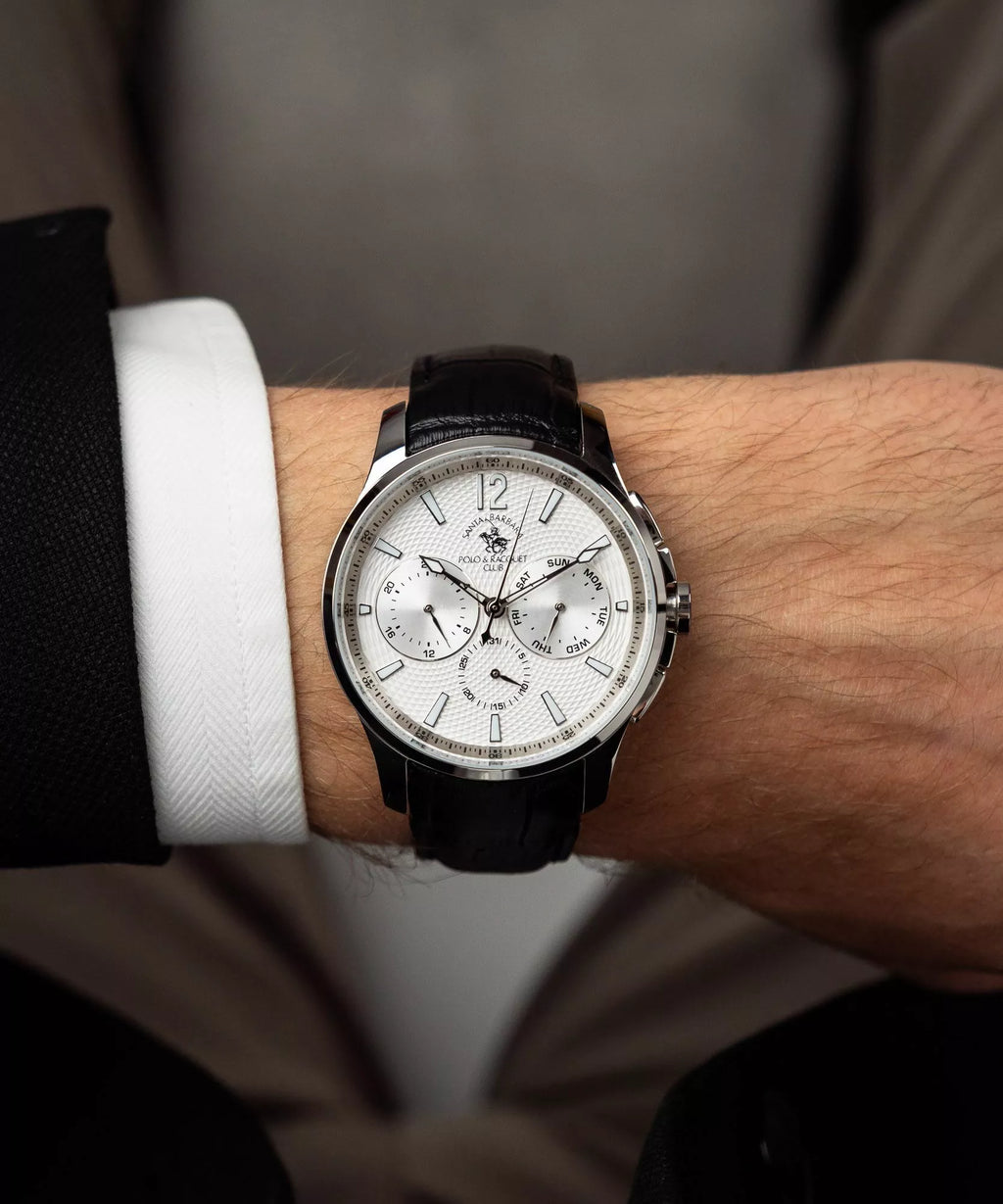 Silver-toned watch with a white textured dial, silver-toned hands, three subdials, and a black textured leather strap.